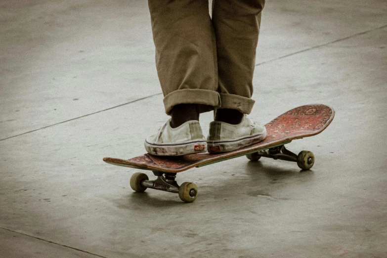 someone wearing white sneakers is riding on a skateboard