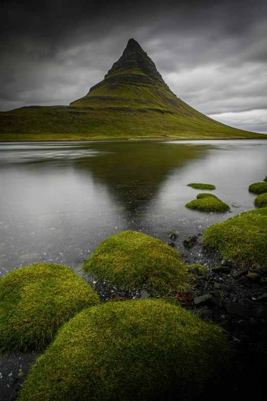 a mountain is surrounded by green grass