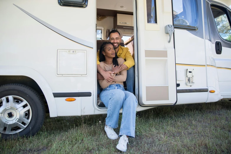 a couple posing for the camera in their camper