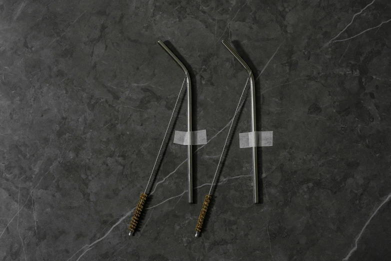 two silver toothbrushes on a grey background