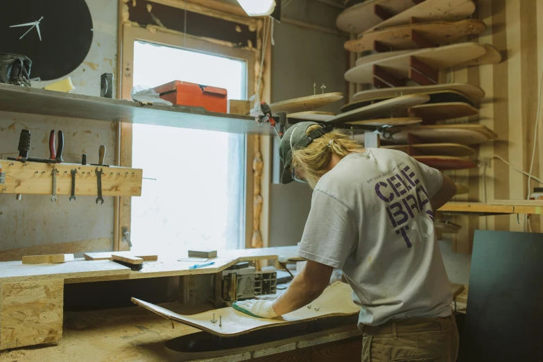 a man working in a shop, making wooden shelves