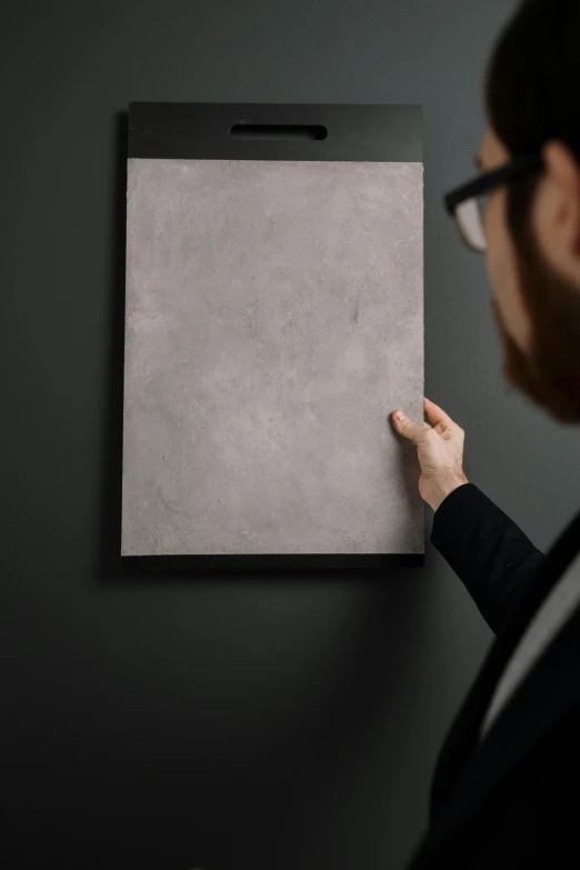 a person holding an object up on a board