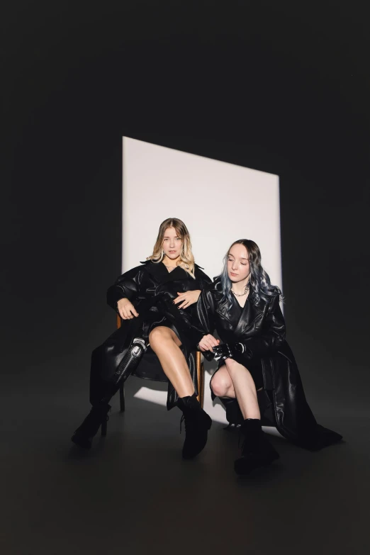 two women pose together for the camera with their black clothes