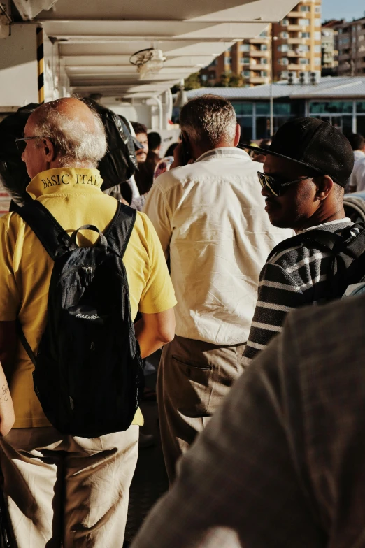 people are lined up outside at a bus station