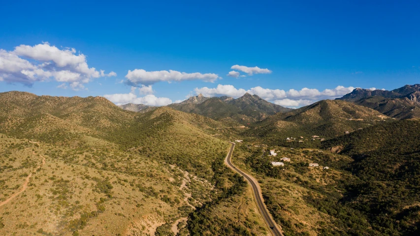 a landscape of green hills and a road with a sky background