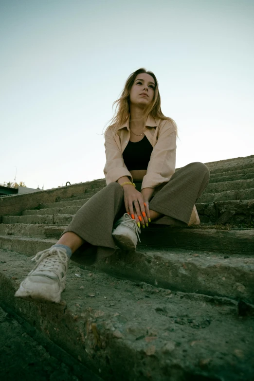 a woman sitting on the concrete steps in a black dress