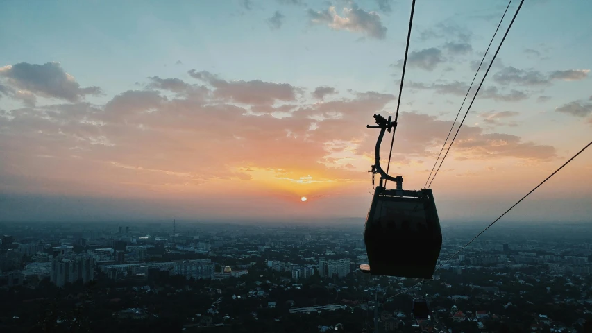 a picture of a tram going over the city and sunset