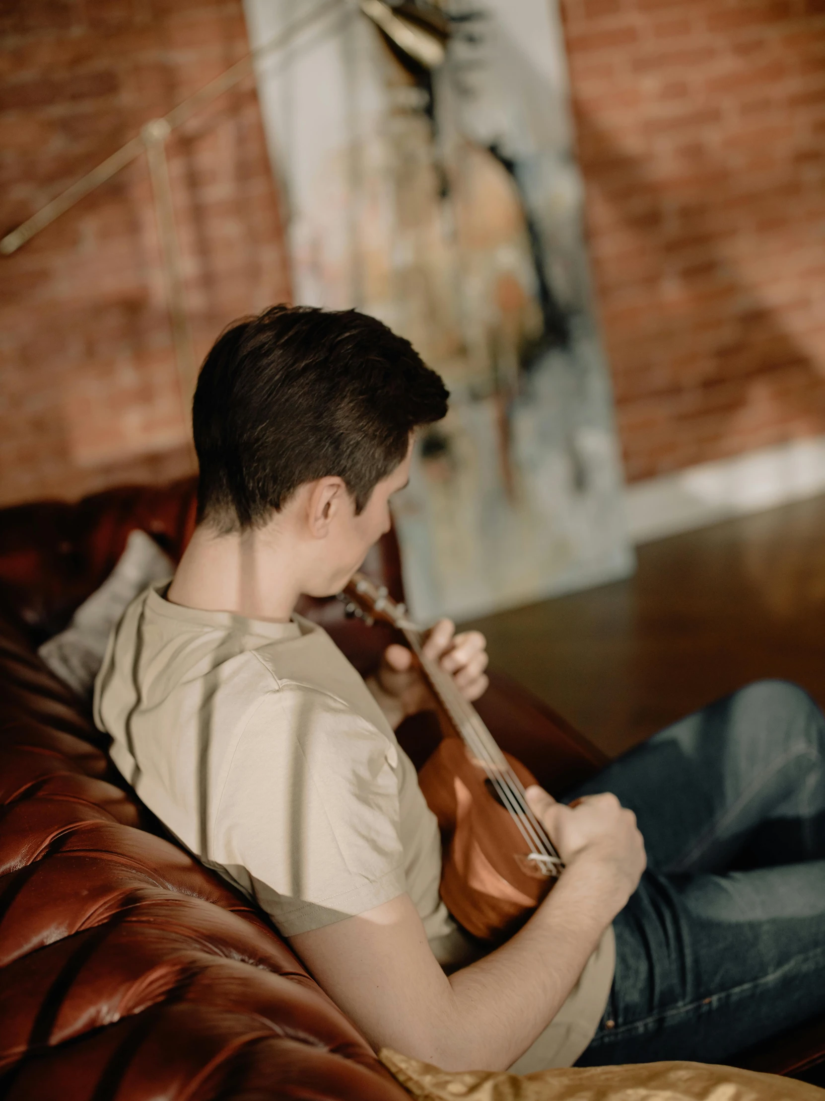 the boy is playing his instruments on the couch