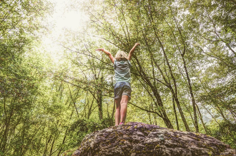 a girl standing on top of a large rock