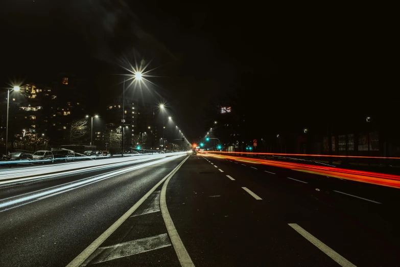 the car lights streak through a city street