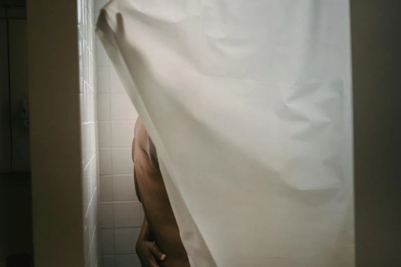 a person's foot peeks through a shower curtain