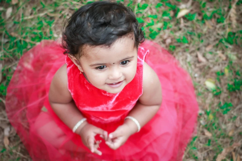 an image of a girl in a dress sitting on the ground