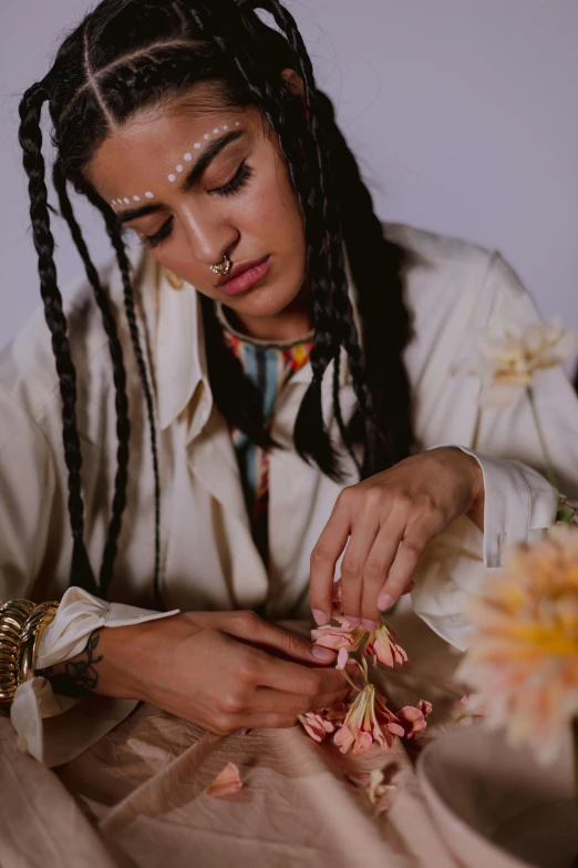 a woman sitting and bending down to petting flowers