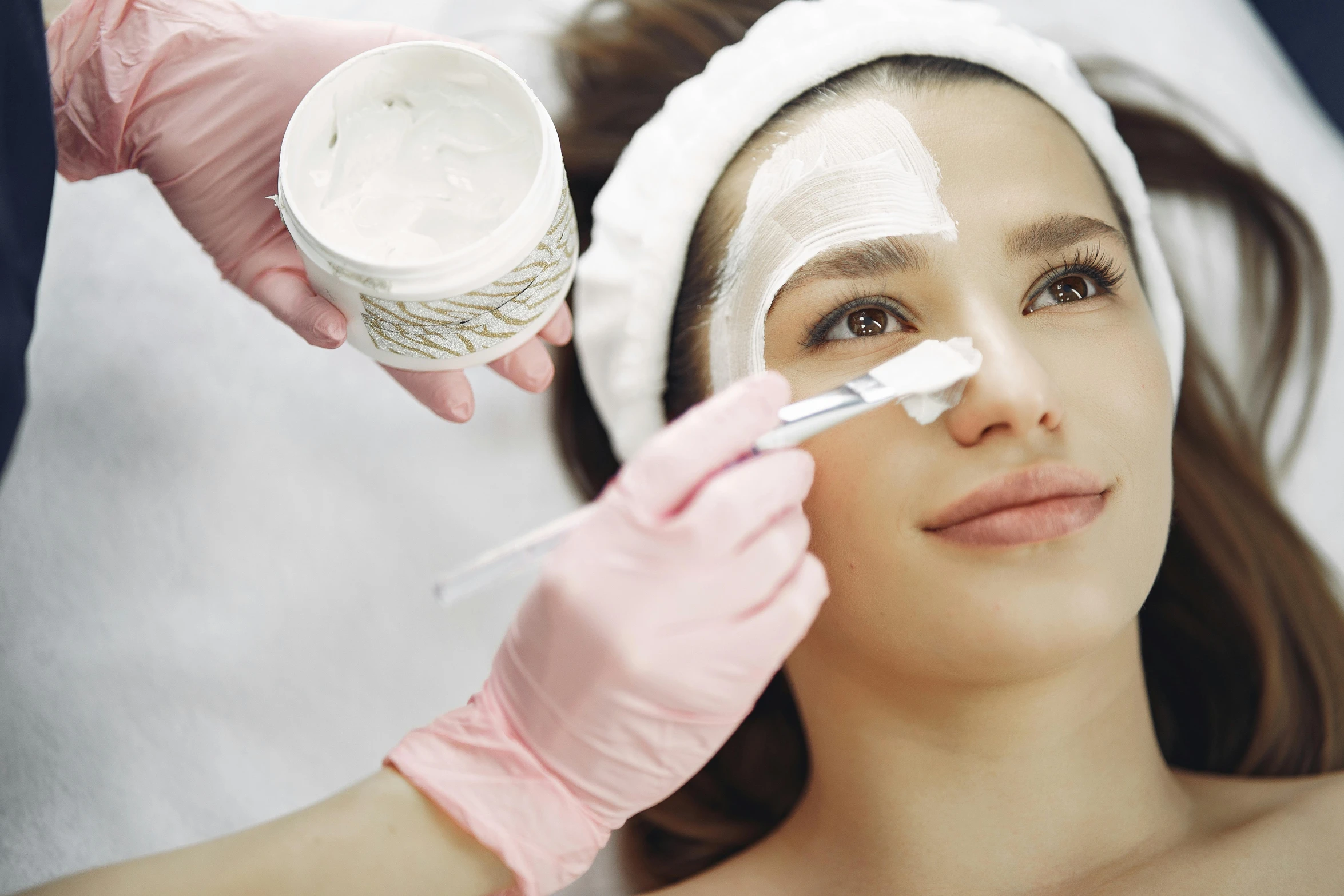 woman receiving cream on face during beauty treatment