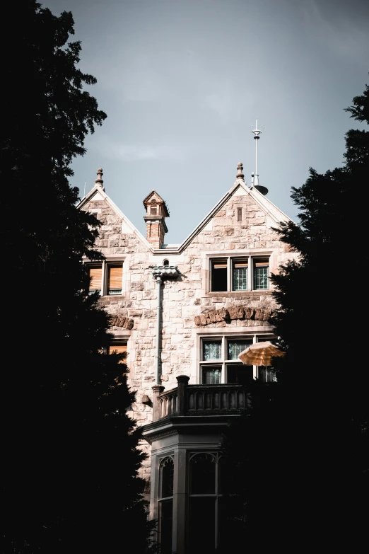 a large brick building with a tower near trees