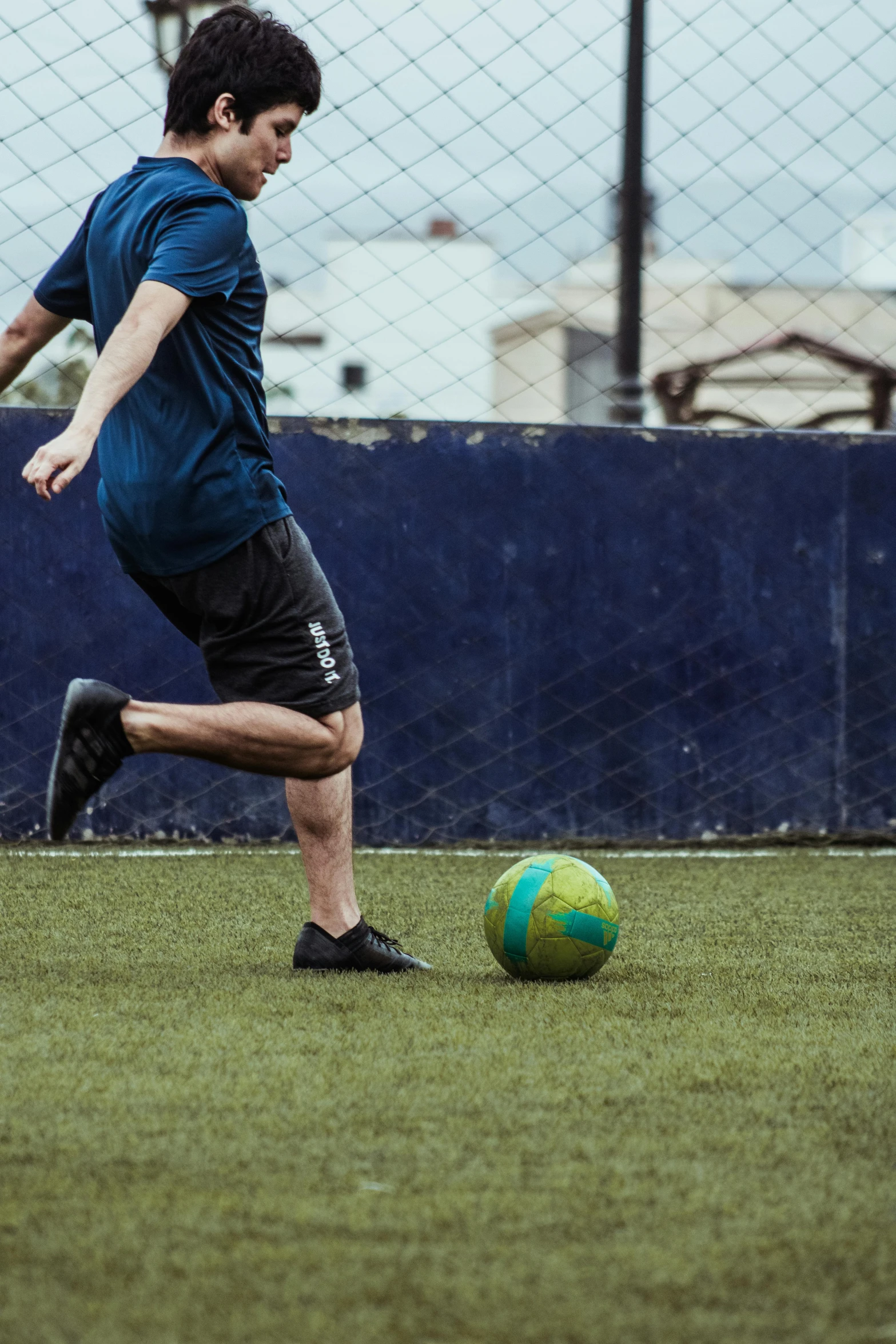 a man in shorts is playing soccer on a grassy field