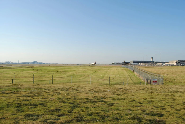 a field with buildings near by and a fence