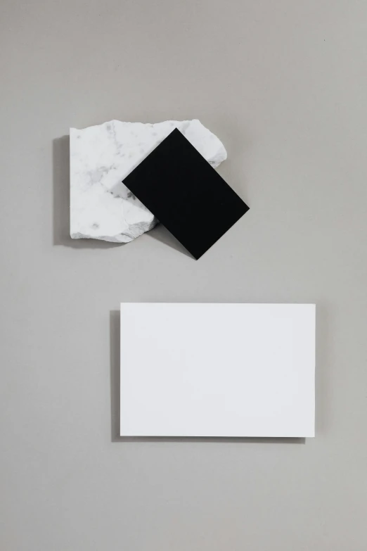white envelope with black square in it between two sheets of paper