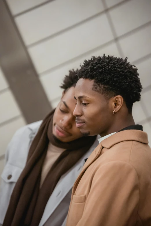 two men standing next to each other in a room