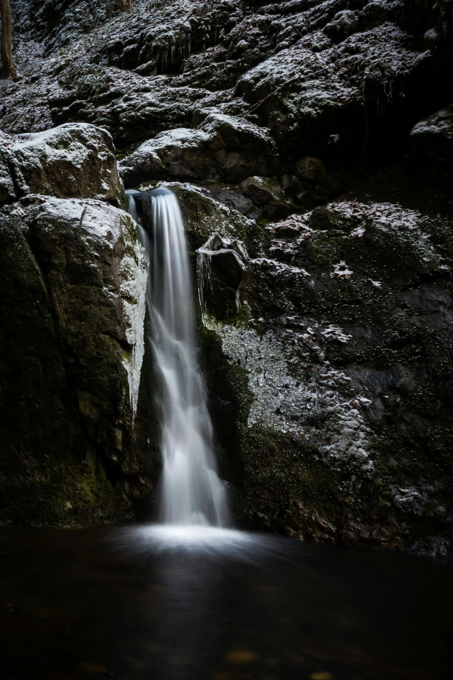 a stream of water next to a rocky cliff