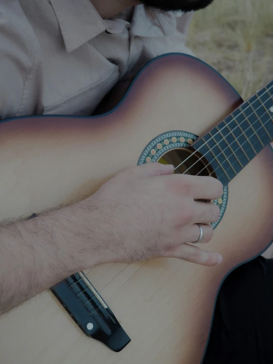 a person that is holding a guitar in their hand