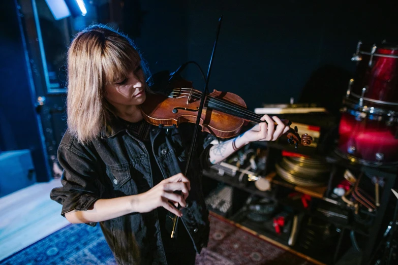 the young woman is playing the violin in her room