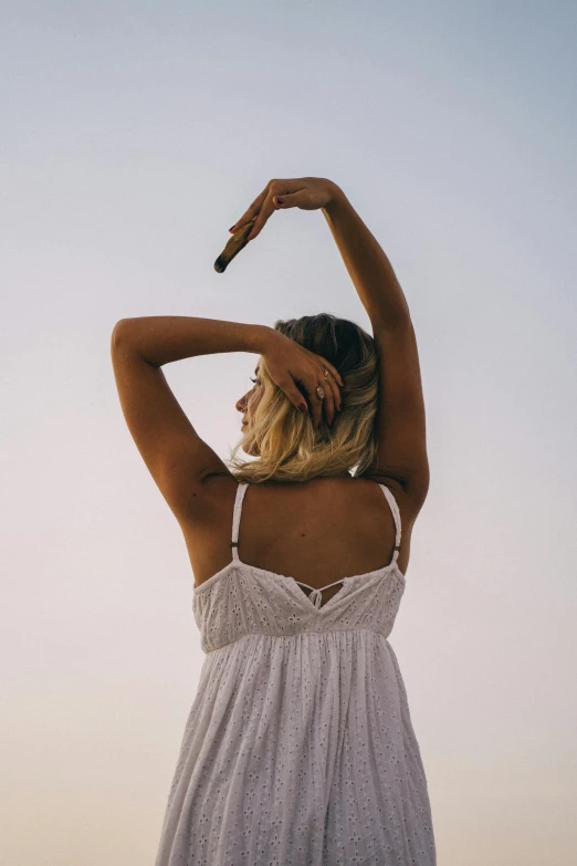 woman with hands behind her head looking back