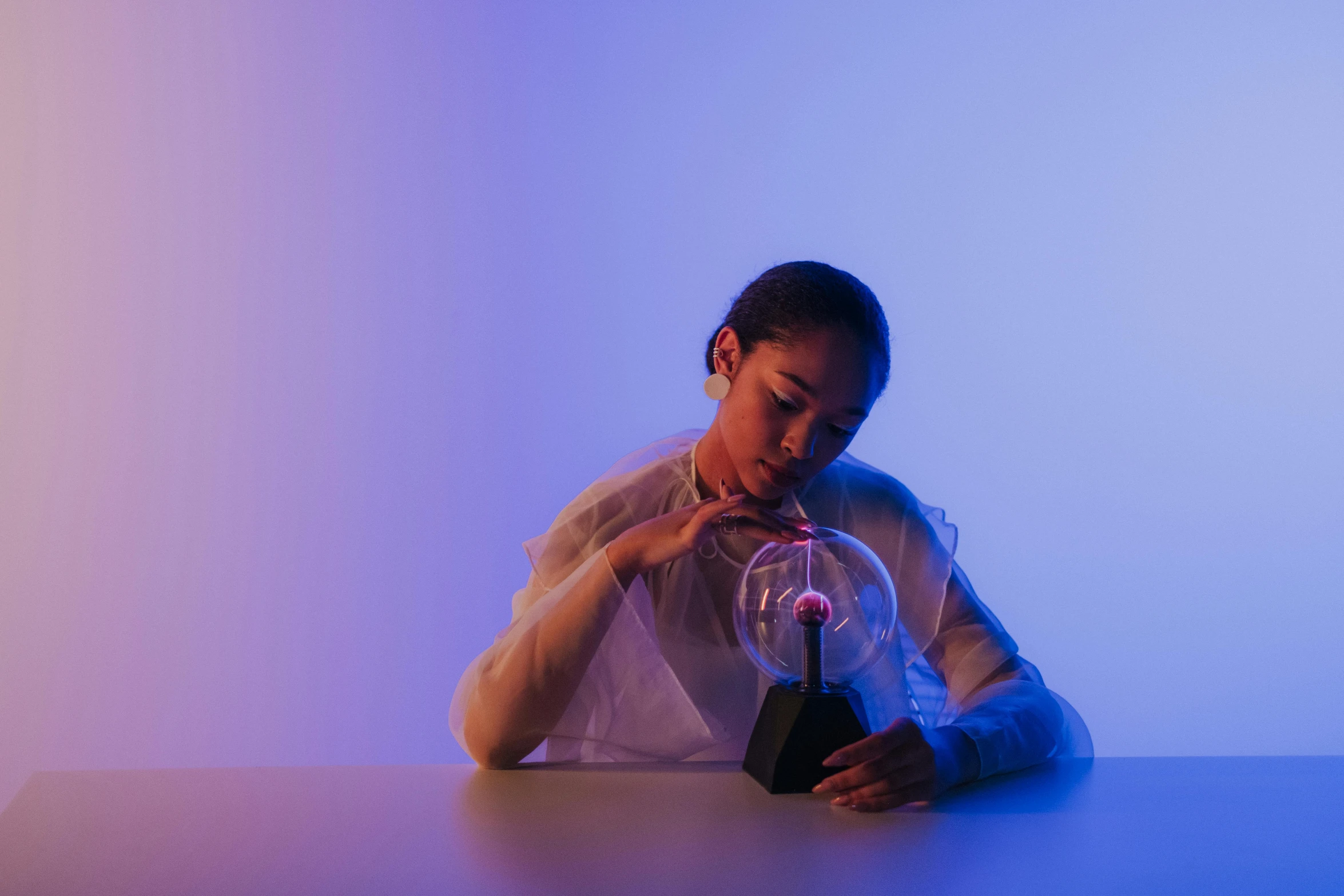 a woman leaning over a table with a light in her hand