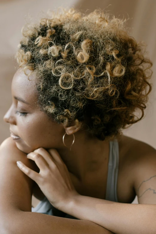 a woman with curly hair stares into the distance