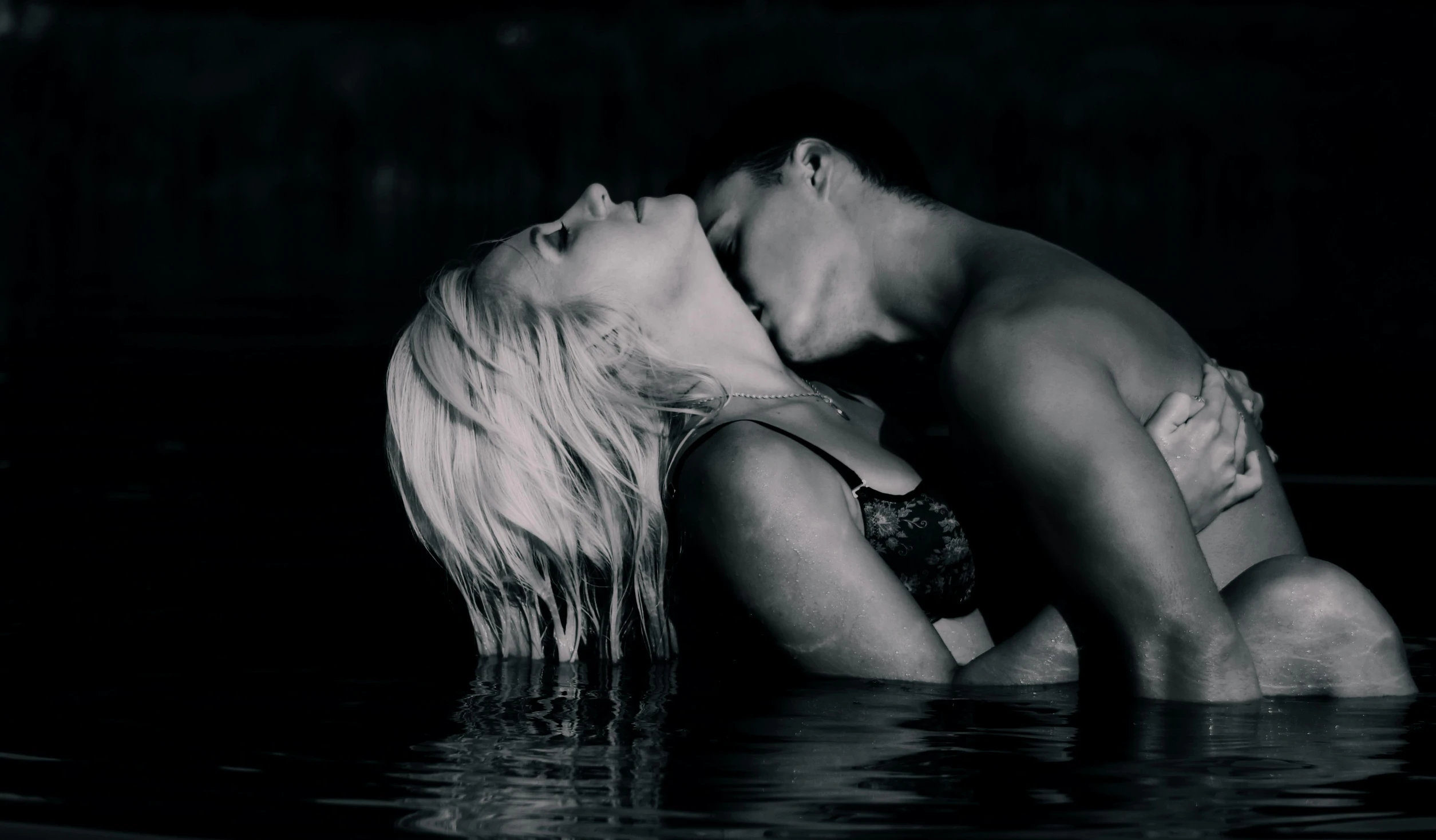 two people in the water kissing and having fun