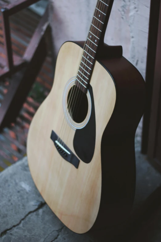 an acoustic guitar is leaning against the wall