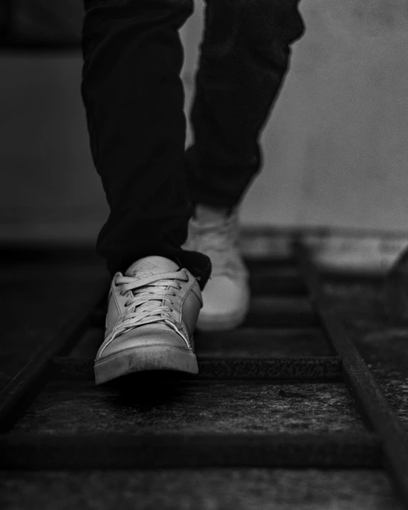 a person's foot with a white tennis shoe