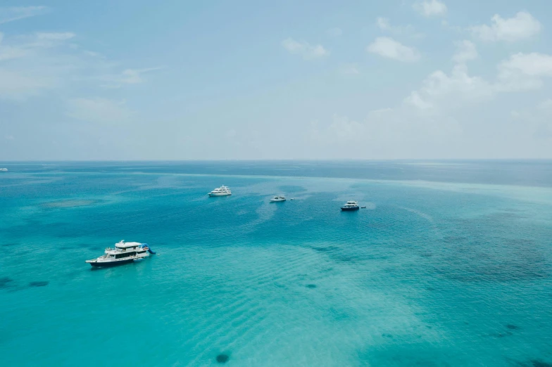 there are several boats floating in the blue water