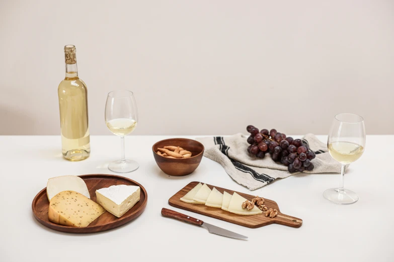 various cheese and wine on a white table