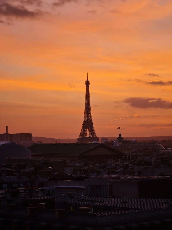 the eiffel tower is silhouetted against the sunset