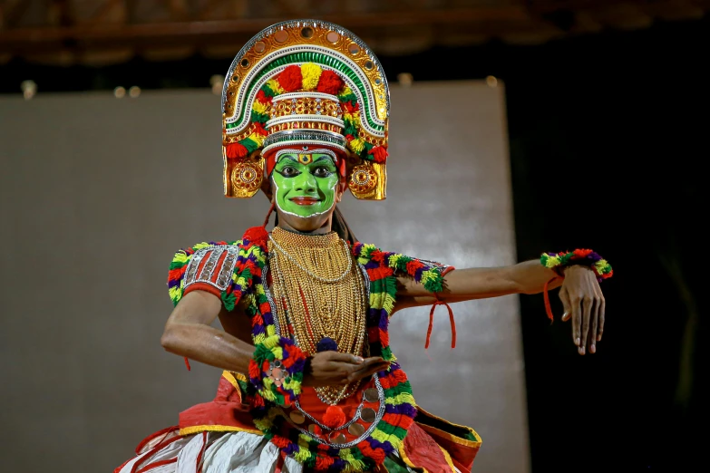 a man with an elaborate mask holds out his arm