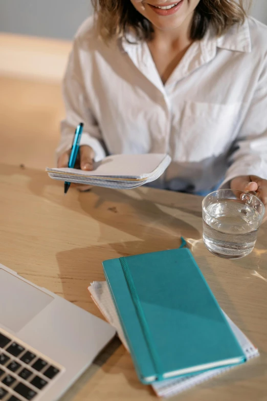 woman sitting at a desk writing on a note pad