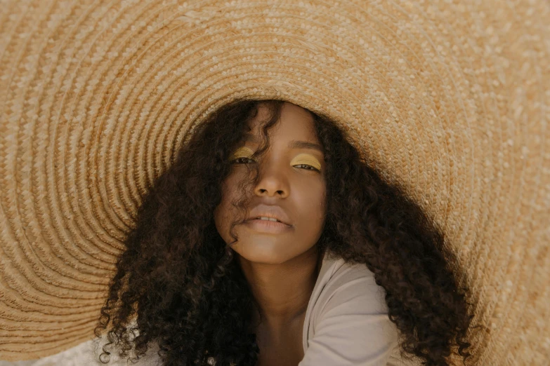 a woman in a large straw hat and blue eyes