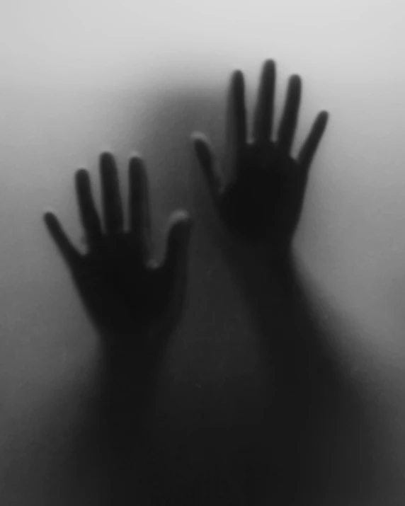 two hands are seen through a mist - filled window