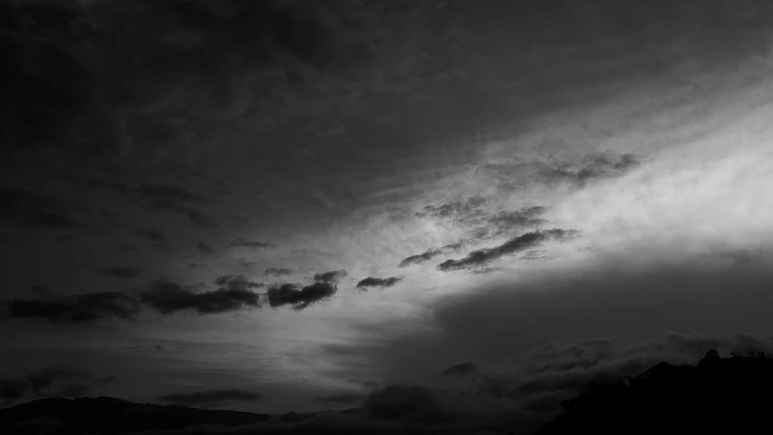 a cloudy sky with trees in the background