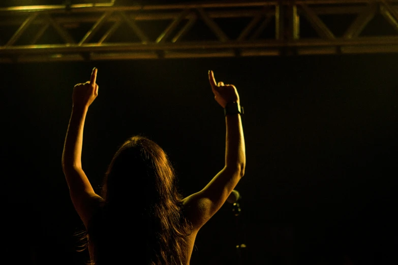 a person is looking up at the sky while holding their hands in the air