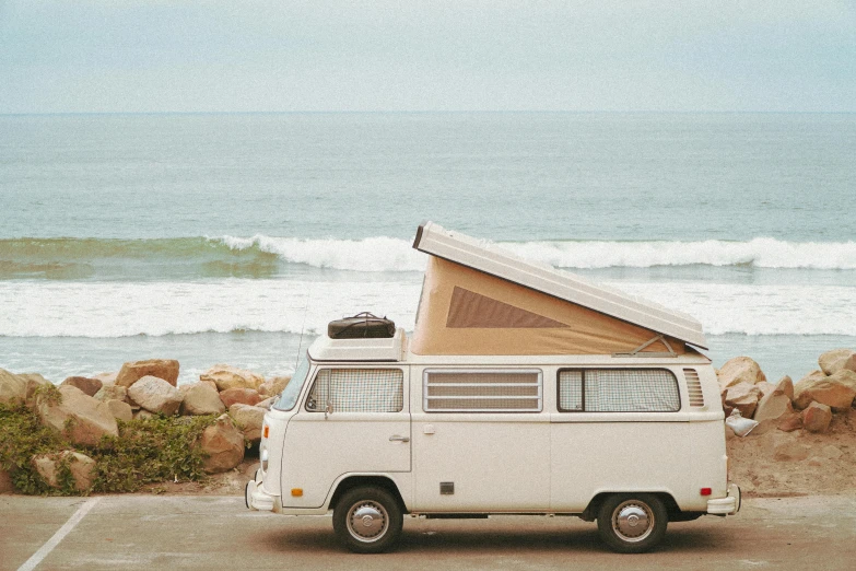 the van is parked by the beach in front of the ocean