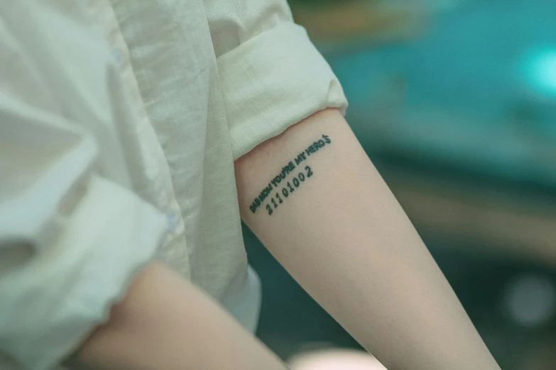 a woman's left arm with a black and white tattoo