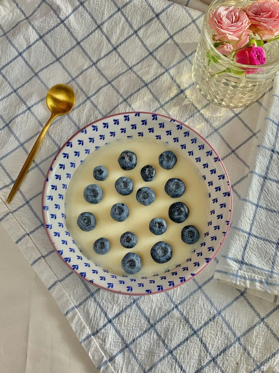yogurt bowl filled with blueberries next to a spoon