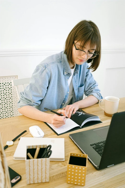 a woman sitting at a table in front of a computer