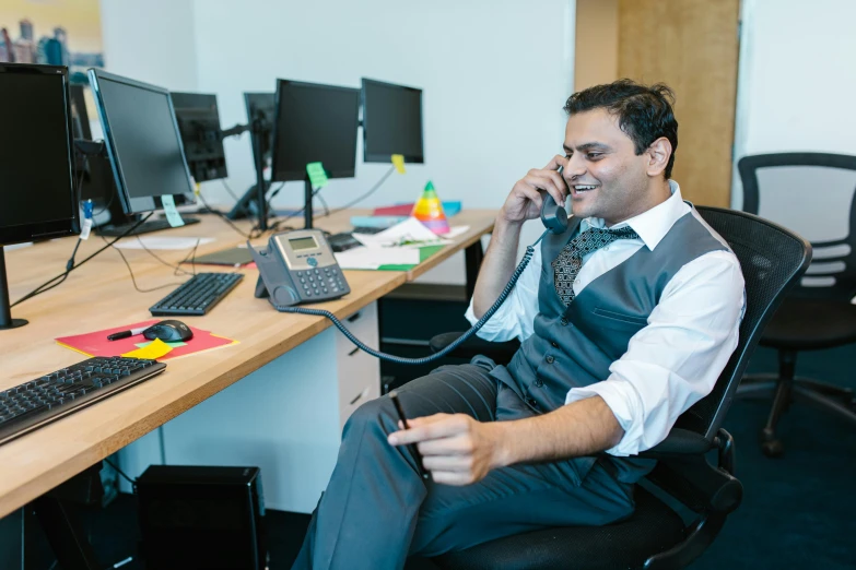 a man sits on a chair and talks on his phone