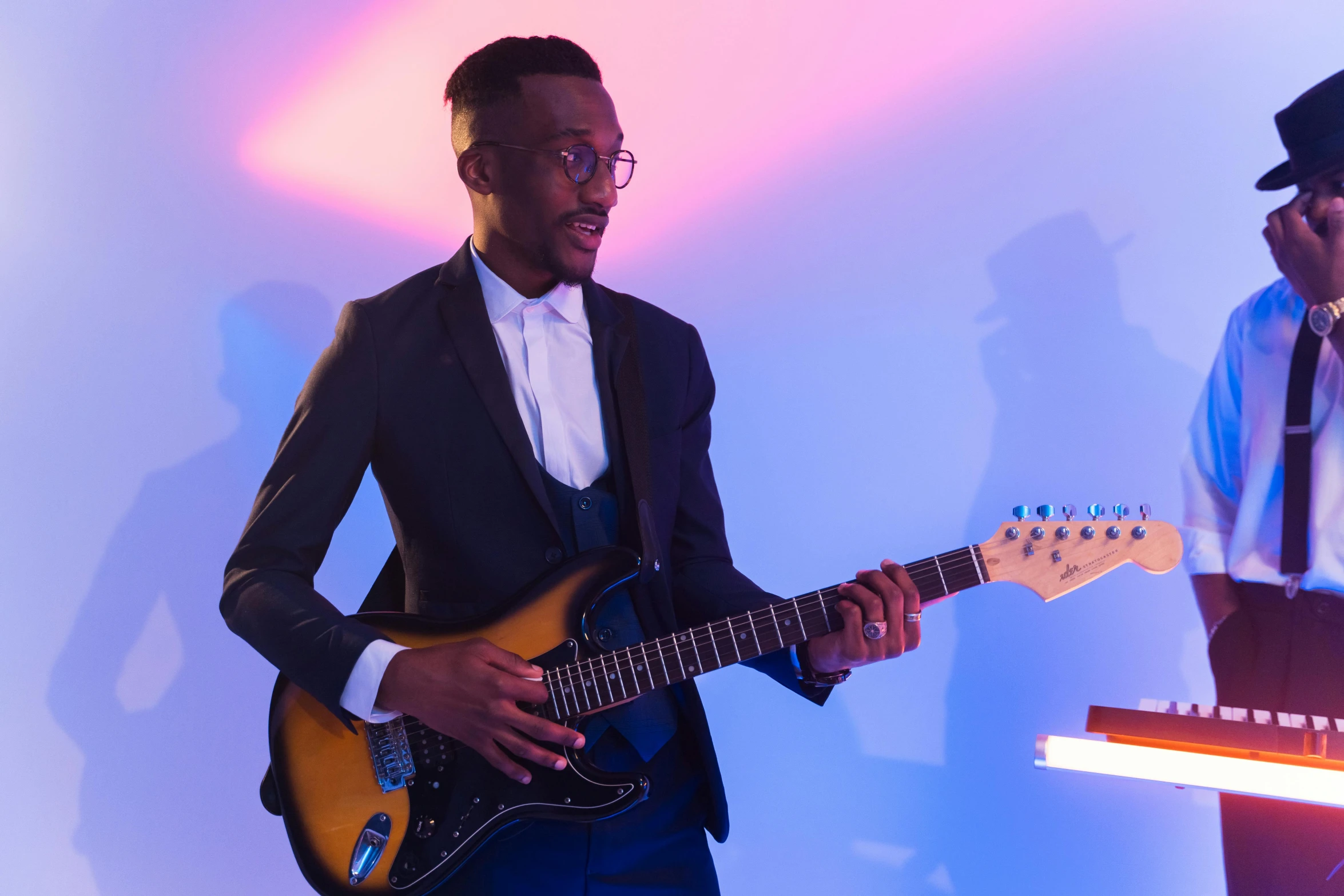 a man with a black and gold hat playing the guitar