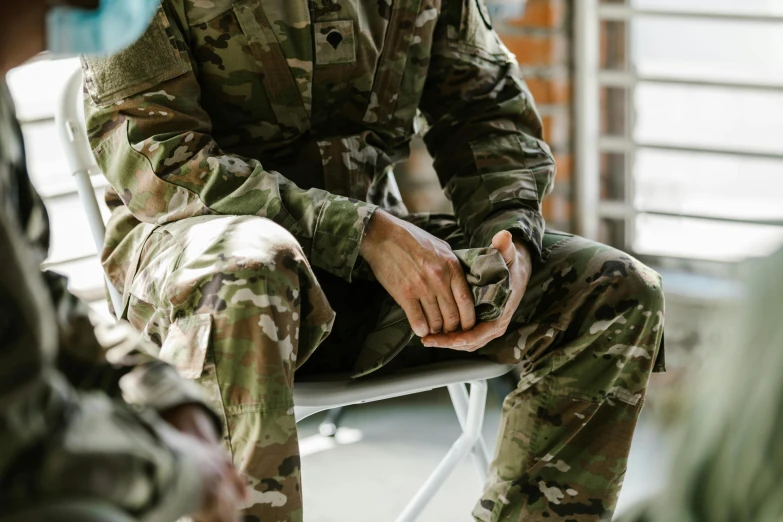 a man in a military suit sitting down on a chair