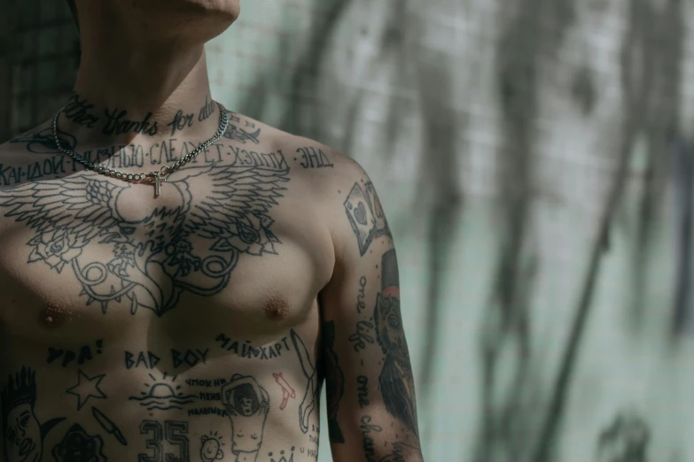 shirtless male with many tattoos and a chain