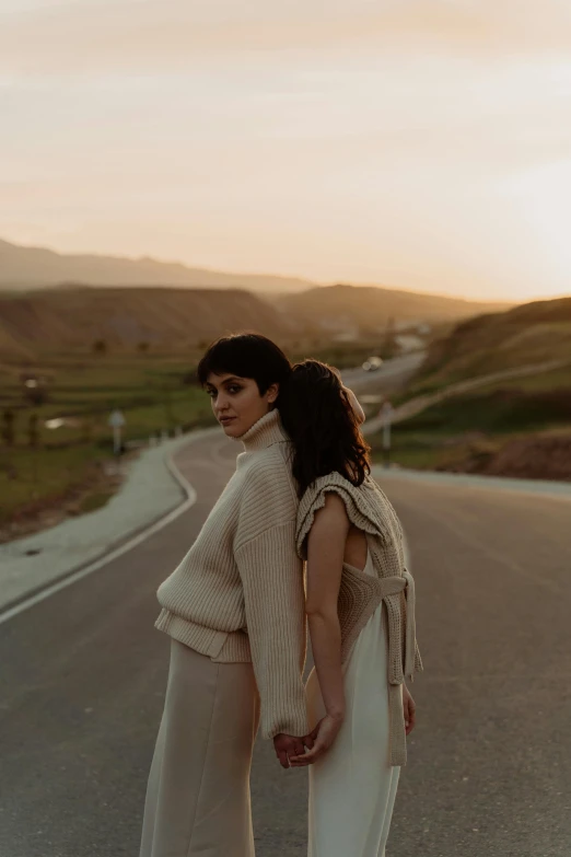 a woman is standing on the side of the road